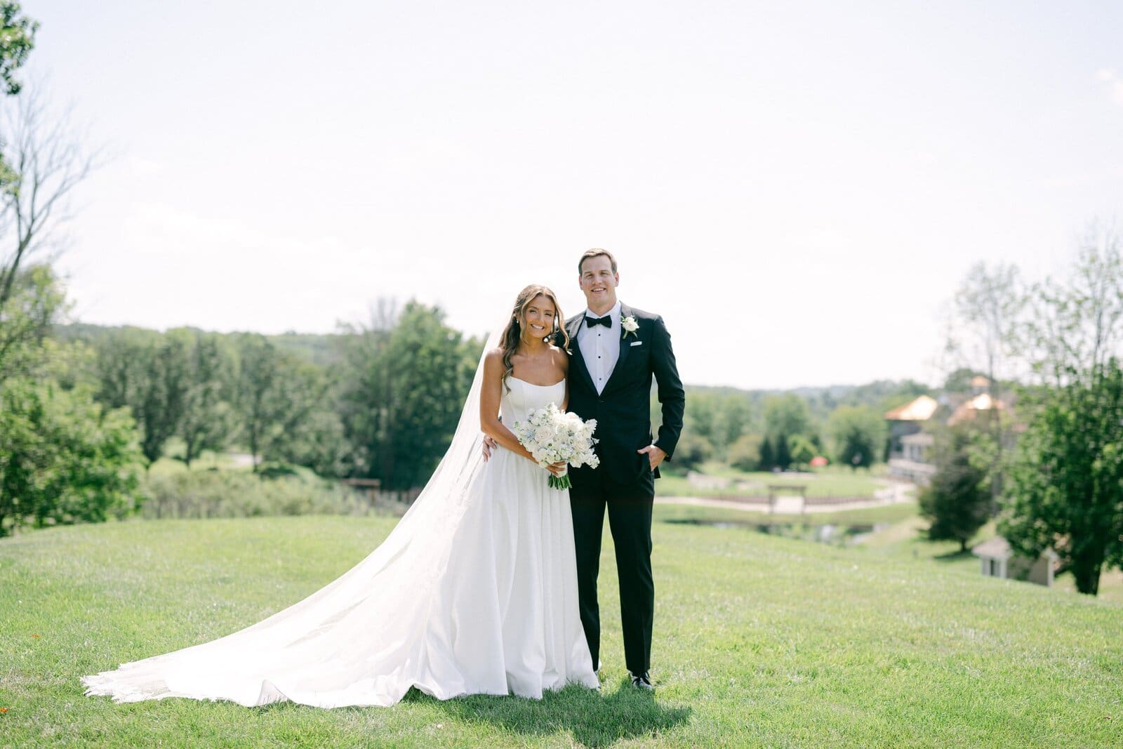Anya and George standing together on the lawn at Bear Brook Valley in Fredon, New Jersey, on their wedding day